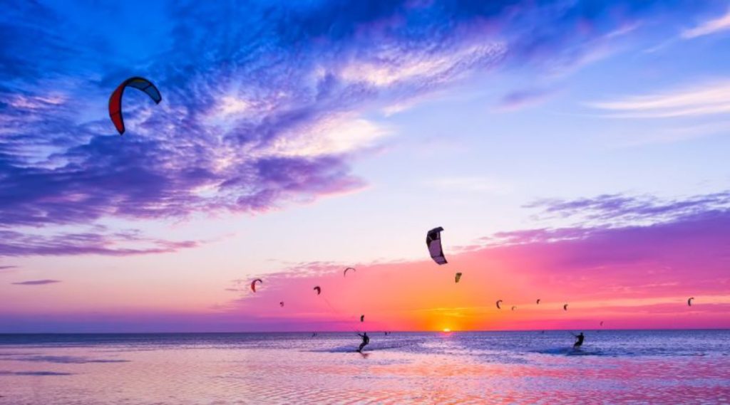 dubai-visa-kite-surfing-against-a-beautiful-sunset-many-silhouettes-of-kit-133722762-min